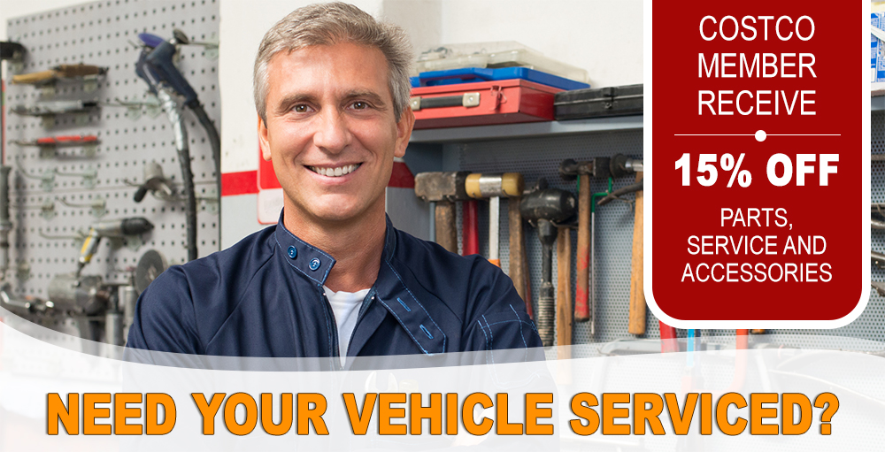 Portrait Of Happy Mature Auto Mechanic In Garage With Tools In Background