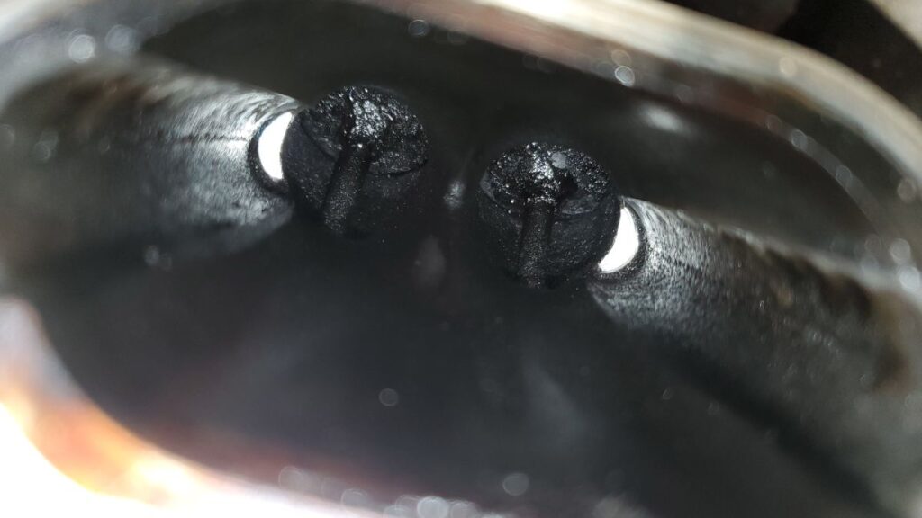 A GDI engine intake with carbon deposits coating the interior and valves.