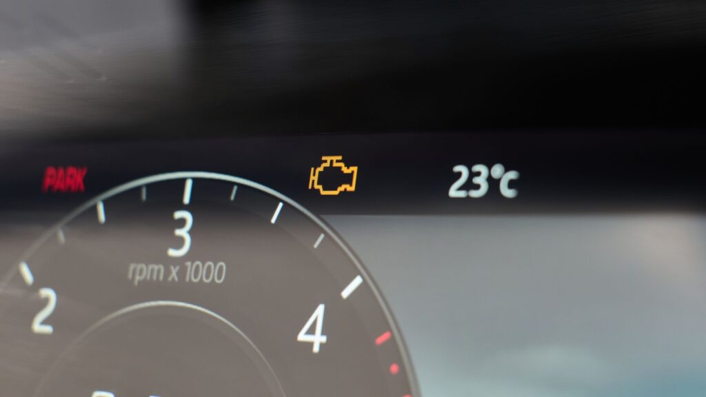Car dashboard display with check engine light illuminated